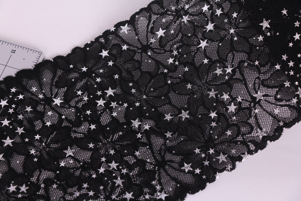 Encaje elástico negro con flores y estrellas plata.