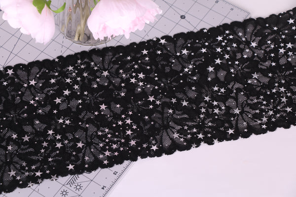 Encaje elástico negro con flores y estrellas plata.